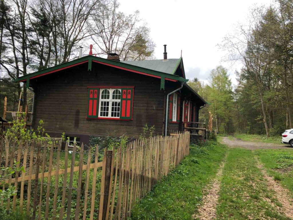Seitenansicht eines Holzhauses mit Holzzaun